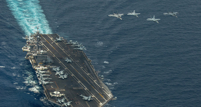 Two F/A-18 Super Hornets and two Royal Malaysian Air Force Mig 29 Fulcrum fly in formation above aircraft carrier USS Carl Vinson